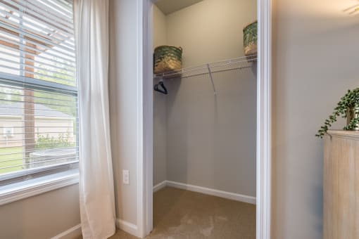 a walk in closet with a large window and a white curtain
