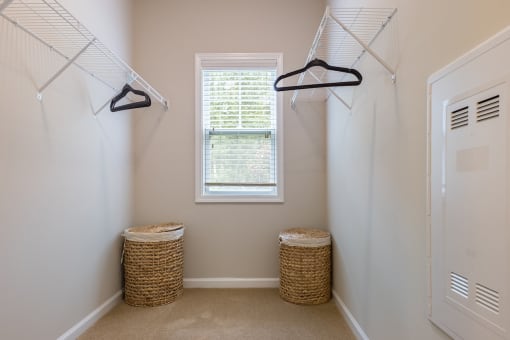 a walk in closet with two baskets and a window