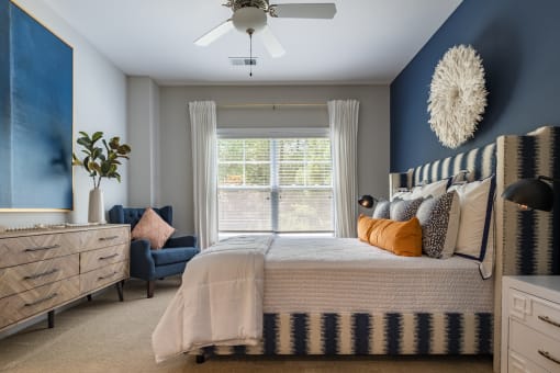 a blue and white bedroom with a bed and a ceiling fan