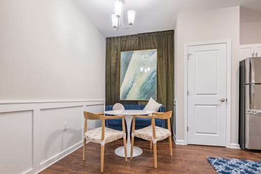 a dining room with a table and chairs and a refrigerator