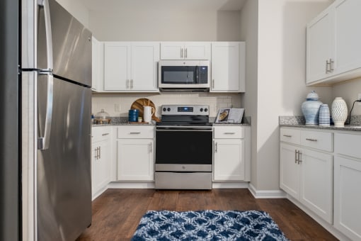 a kitchen with stainless steel appliances and white cabinets