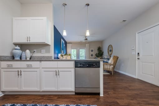 a kitchen with white cabinets and a stainless steel dishwasher