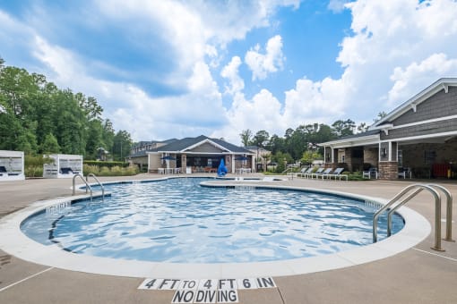 a large pool with a house in the background