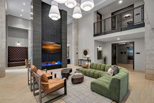A modern living room with a fireplace and a green sofa.