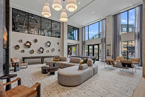A large, modern living room with a couch, chairs, and a fireplace.