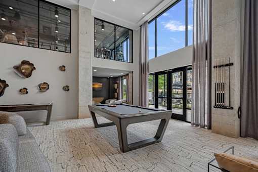A room with a pool table and a couch.
