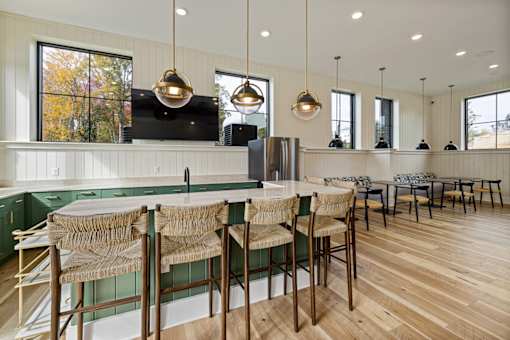 A kitchen with wooden floors and green backsplash.