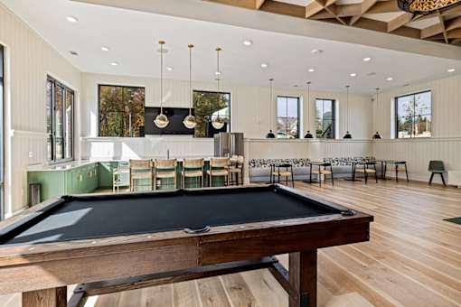 A billiard table is in the middle of a room with a pool table.