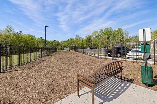 A park with a bench and a fence.