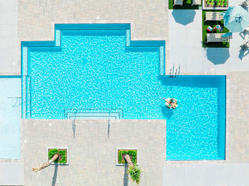 A person is floating in a blue pool.