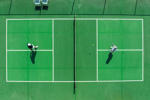 Two tennis players on a green court.