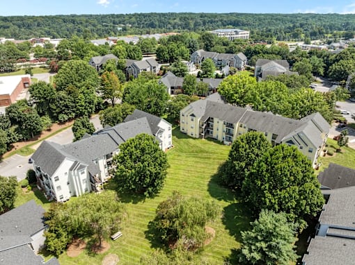 A bird's eye view of a residential area with houses and trees at Heights at New Garden apartments in Greensboro, NC.