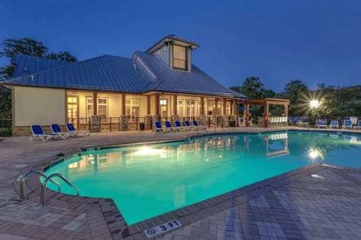 Asheville, NC, Pet-Friendly Apartments - Reserve at Asheville - Swimming Pool with Blue Loungers, Pergola, and a View of the Clubhouse.