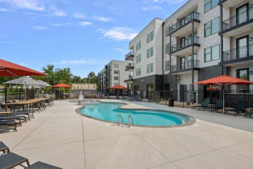 A swimming pool area with a building in the background.