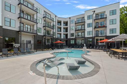 A swimming pool area with a building in the background.