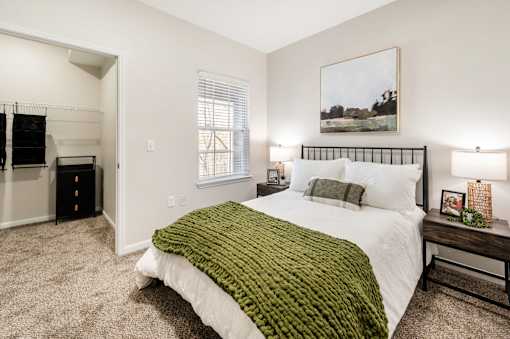 A bedroom with a large bed and a painting on the wall.