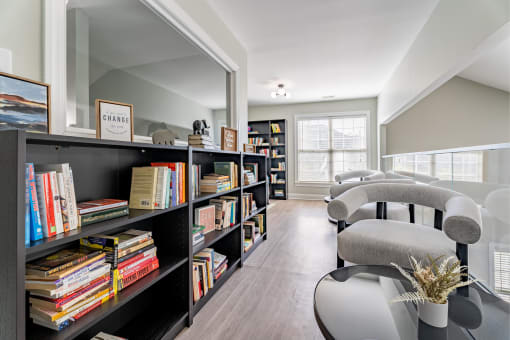 a living room with a bookshelf filled with books    and chairs