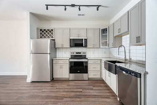 A kitchen with a refrigerator, oven, and microwave.