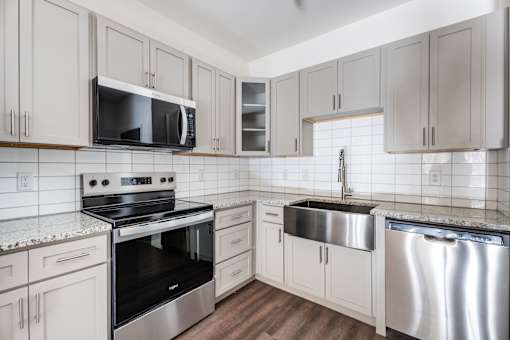 A kitchen with white cabinets and a stainless steel dishwasher.