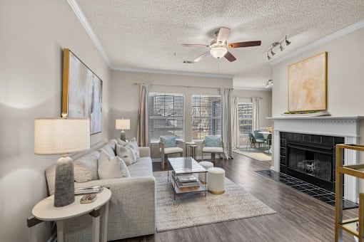 A living room with a fireplace and a couch at Heights at New Garden apartments in Greensboro, NC.