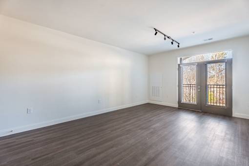A room with wooden flooring and a sliding glass door.