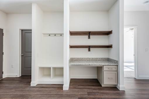 A white room with a desk and drawers.