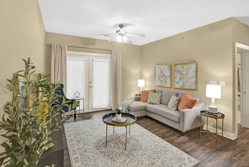 A living room with a couch, a coffee table, and a ceiling fan.