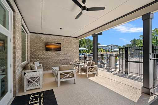 A patio with a black rug that says "LET" on it.