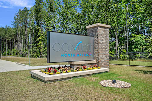 A sign that says "COVENT" is in front of a forest.