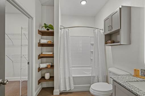 A white bathroom with a toilet, sink, and shower.