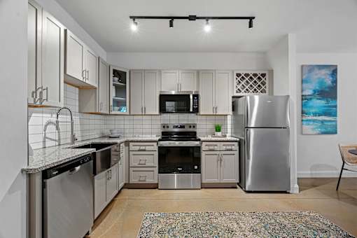 A modern kitchen with stainless steel appliances and wooden floors.