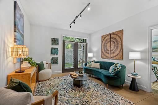 A living room with a green couch and a rug.