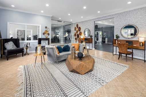 A modern living room with a large rug and a coffee table.