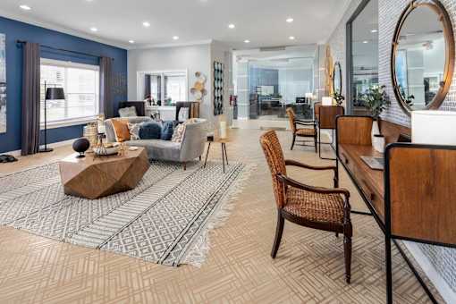 A living room with a large rug and a wooden coffee table.