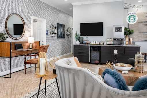 A modern living room with a grey sofa, a wooden table, and a TV mounted on the wall.
