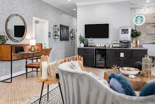 A living room with a grey sofa, a wooden table, a TV, and a coffee machine.