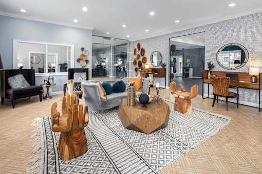 Clubhouse interior with a seating area of a couch and chairs surrounding a wooden coffee table.