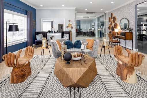 Clubhouse seating area with a sofa, a wooden coffee table, decor and a large window nearby.