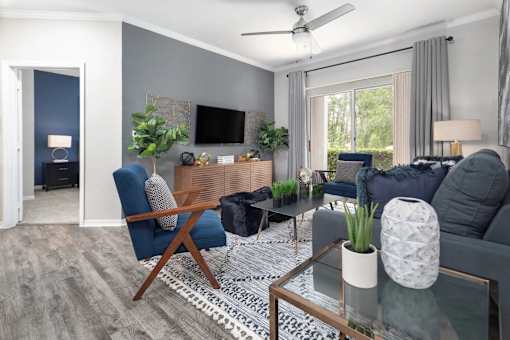 A living room with a blue chair, a grey couch, and a coffee table.