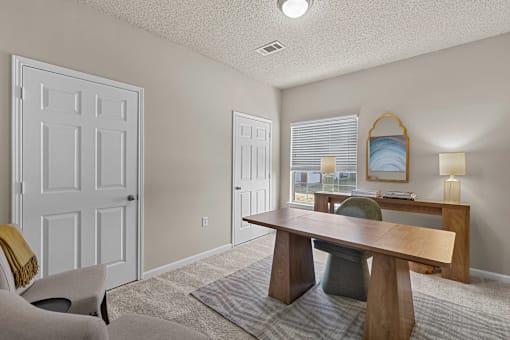 A room with a table, chairs, and a window at Heights at New Garden apartments in Greensboro, NC.