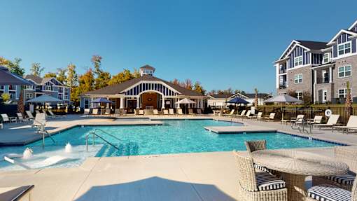 A large swimming pool with a slide and a building in the background.