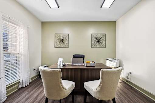 Two chairs are placed in front of a desk with a laptop and a printer on it at Evergreen at the Bluffs apartments in Knoxville, TN..