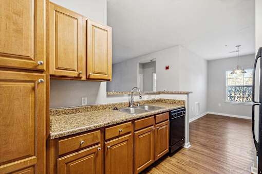 A kitchen with wooden cabinets and a granite countertop.