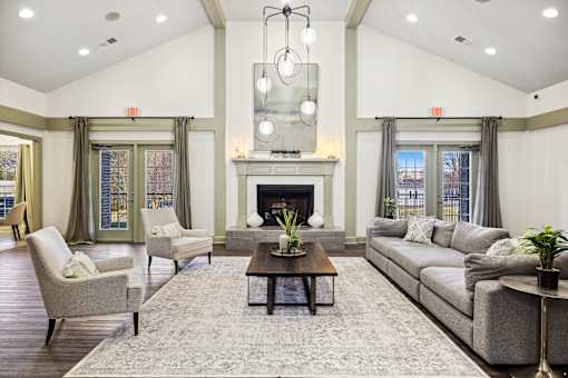 A large, well-lit living room with a fireplace and comfortable seating at Evergreen at the Bluffs apartments in Knoxville, TN.