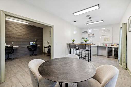 A modern dining area with a round table and chairs at Evergreen at the Bluffs apartments in Knoxville, TN..