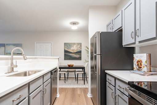 A modern kitchen with a black refrigerator and stove.