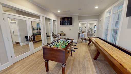A room with a pool table and a bench.