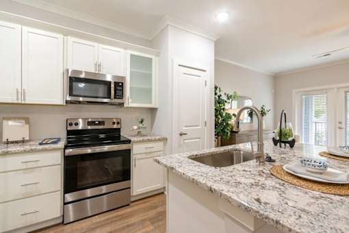 A kitchen with a granite countertop and stainless steel appliances.