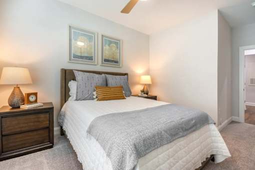 A bedroom with a bed, nightstand, and two lamps.