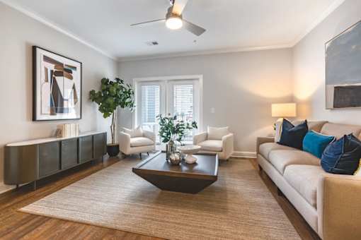 A living room with a white couch, a coffee table, and a painting on the wall.